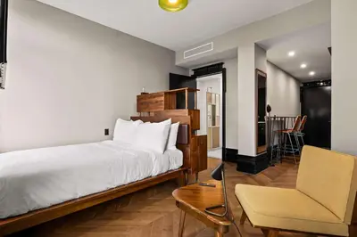 a bedroom with a bed and a desk and a chair at Freeman 1001 by Rove Travel - Studio with Shared Amenities in New York