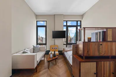 a living room with a couch and a tv at Freeman 1101 by Rove Travel - Studio with Shared Amenities in New York