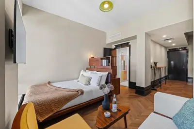 a bedroom with a bed and a living room at Freeman 1101 by Rove Travel - Studio with Shared Amenities in New York