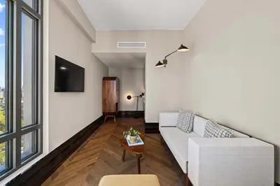 a living room with a white couch and a tv at Freeman 403 by Rove Travel - 1BR Condo with Shared Amenities in New York