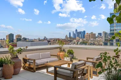 a patio with a table and chairs on a roof at Freeman 903 by Rove Travel - 1BR Condo with Shared Amenities in New York