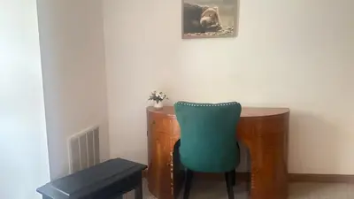 a desk with a green chair next to a table at Blue Bird Chalet 5BR with Sauna near Skiing in East Chatham