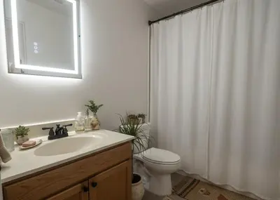 a bathroom with a sink and a toilet and a mirror at Blue Bird Chalet 5BR with Sauna near Skiing in East Chatham