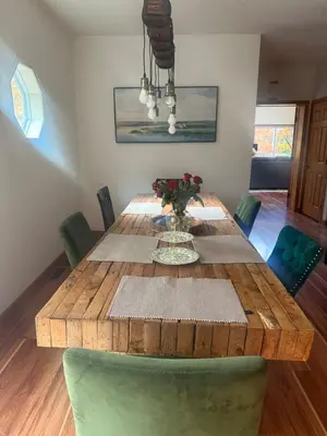 a dining room with a wooden table and green chairs at Blue Bird Chalet 5BR with Sauna near Skiing in East Chatham