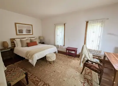 a bedroom with a bed and a desk and windows at Blue Bird Chalet 5BR with Sauna near Skiing in East Chatham