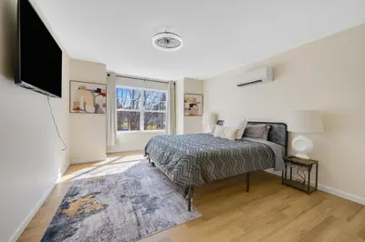 a bedroom with a bed and a flat screen tv at Spacious 5BR Home KING Bed Wi-Fi Parking in Bloomfield