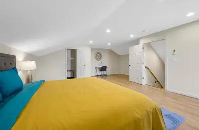 a large bedroom with a yellow bed and a desk at Spacious 5BR Home KING Bed Wi-Fi Parking in Bloomfield
