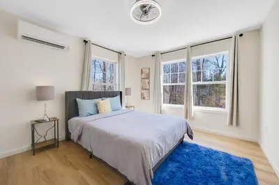 a bedroom with a bed and two windows at Spacious 5BR Home KING Bed Wi-Fi Parking in Bloomfield