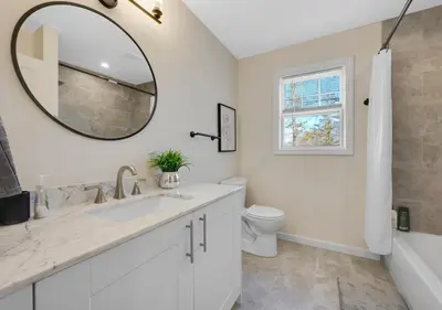 a white bathroom with a sink and a mirror at Spacious 5BR Home KING Bed Wi-Fi Parking in Bloomfield