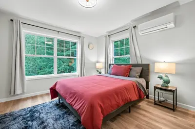 a bedroom with a red bed and two windows at Old, Unlisted in Bloomfield