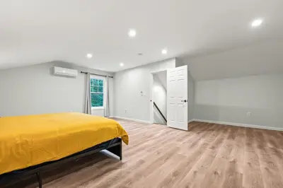 a bedroom with a yellow bed and a wooden floor at Old, Unlisted in Bloomfield