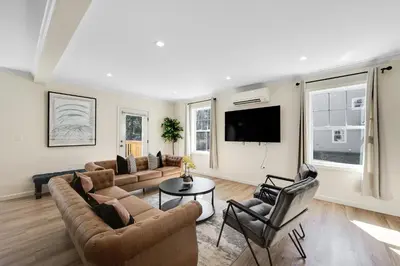 a living room with a couch and chairs and a tv at Old, Unlisted in Bloomfield