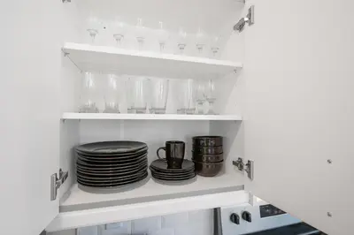 a pantry with plates and glasses on shelves at Old, Unlisted in Bloomfield