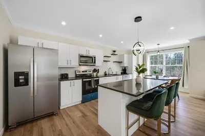 a kitchen with white cabinets and a stainless steel refrigerator at Old, Unlisted in Bloomfield