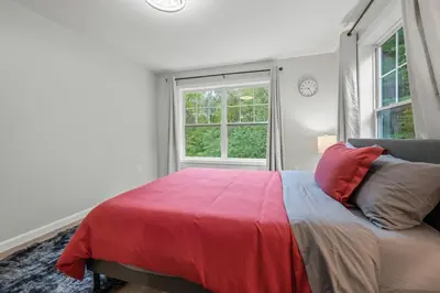 a bedroom with a bed with a red blanket and a window at Luxury 5BR Home in Central Bloomfield Spot in Bloomfield