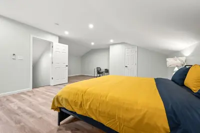 a bedroom with a bed with a yellow blanket at Luxury 5BR Home in Central Bloomfield Spot in Bloomfield