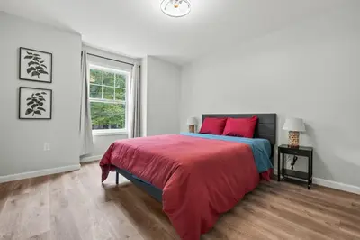 a white bedroom with a bed and a window at Luxury 5BR Home in Central Bloomfield Spot in Bloomfield