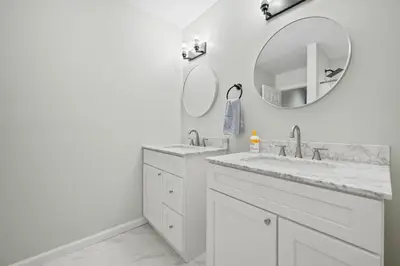 a white bathroom with two sinks and a mirror at Luxury 5BR Home in Central Bloomfield Spot in Bloomfield