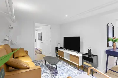 a living room with a couch and a tv at 20 Mins to Times Sq. EWR | Cozy Apartment | Sleeps 4 in Jersey City