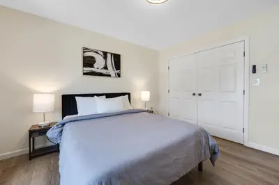 a white bedroom with a large bed and two lamps at Elegant 2 Story Bloomfield 3 Kings 2 Queens in Bloomfield