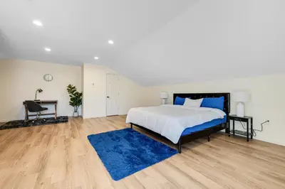 a bedroom with a large bed and a blue rug at Elegant 2 Story Bloomfield 3 Kings 2 Queens in Bloomfield