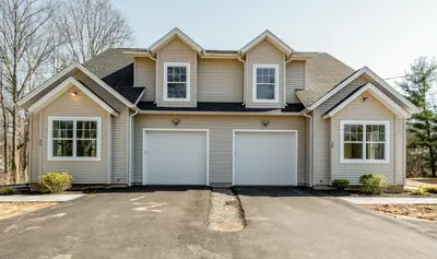 a house with two garage doors in a driveway at Elegant 2 Story Bloomfield 3 Kings 2 Queens in Bloomfield