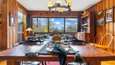 a dining room with a wooden table and a large window at Discounted Winter Rates Ski Retreat Hot Tub Fire Pit Windham Mountain House in Windham
