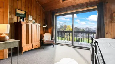a bedroom with a bed and a large sliding glass door at Discounted Winter Rates Ski Retreat Hot Tub Fire Pit Windham Mountain House in Windham