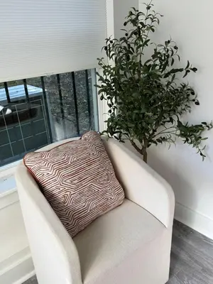 a pillow sitting on a couch next to a plant at Cozy Retreat Near EWR with NYC access in Newark