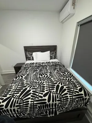 a black and white bed in a white room at Cozy Retreat Near EWR with NYC access in Newark