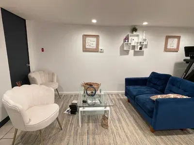 a living room with a blue couch and white chairs at Hidden Gem BK in Brooklyn
