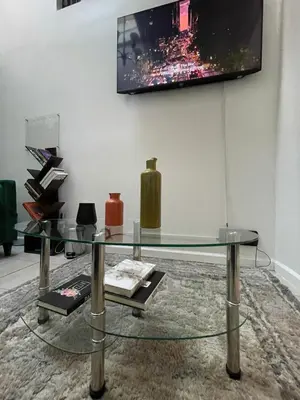a glass table in a room with a tv on a wall at Hidden Gem BK in Brooklyn
