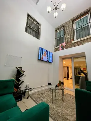a living room with a couch and a tv on the wall at Hidden Gem BK in Brooklyn