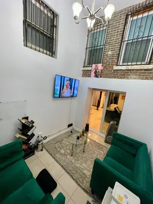 a living room with two green couches and a flat screen tv at Hidden Gem BK in Brooklyn