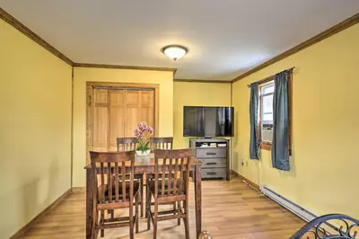 a dining room with a table with chairs and a television at Relaxing Premium Suite Near Ski Resort in Pleasant Mount