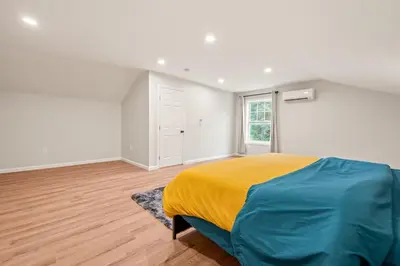 a bedroom with a bed with a yellow blanket at Spacious House with King Beds in Prime Location in Bloomfield