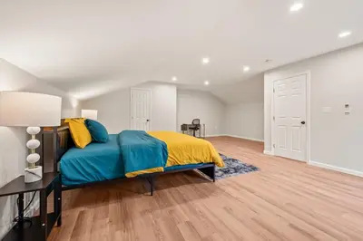 a bedroom with a bed with a blue and yellow blanket at Spacious House with King Beds in Prime Location in Bloomfield