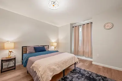 a bedroom with a bed and a clock on the wall at Spacious House with King Beds in Prime Location in Bloomfield