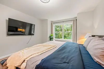 a bedroom with a bed with a flat screen tv on the wall at Spacious House with King Beds in Prime Location in Bloomfield