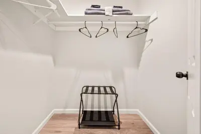 a towel rack with a black chair in a room at Spacious House with King Beds in Prime Location in Bloomfield