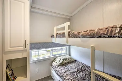 a small room with two bunk beds and a window at Gather, Celebrate, Unwind Close to Ski Trails in Pleasant Mount