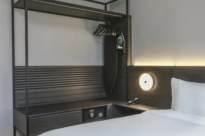 a hotel room with a bed and a mirror at AC Hotel by Marriott Saratoga Springs in Saratoga Springs