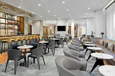 a restaurant with tables and chairs and a bar at AC Hotel by Marriott Saratoga Springs in Saratoga Springs
