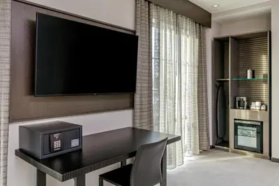 a dining room with a table and a television on a wall at AC Hotel by Marriott Saratoga Springs in Saratoga Springs