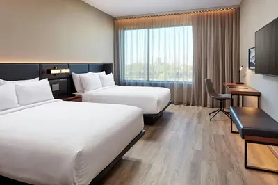 a hotel room with two beds and a desk at AC Hotel by Marriott Saratoga Springs in Saratoga Springs