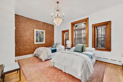 a bedroom with two beds and a brick wall at Harlem Gem in New York