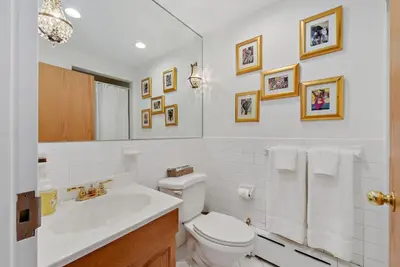 a white bathroom with a toilet and a sink at Harlem Gem in New York