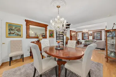 a dining room with a table and white chairs at Harlem Gem in New York