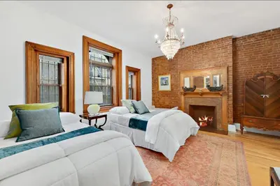 a large bedroom with two beds and a fireplace at Harlem Gem in New York
