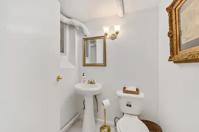 a white bathroom with a toilet and a sink at Harlem Gem in New York